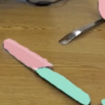 Image from the CookAR prototype: kitchen items scattered on a table. Green color over handles shows grabbable areas. Red/pink overlays indicate hazards such as blades or potentially hot and food-containing areas.